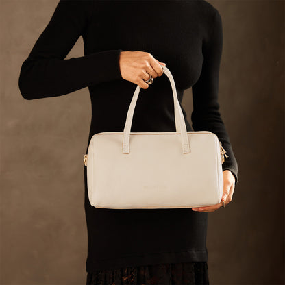 Pebbled Bone*Oversized | Model holding mini duffle shaped handbag with crossbody strap