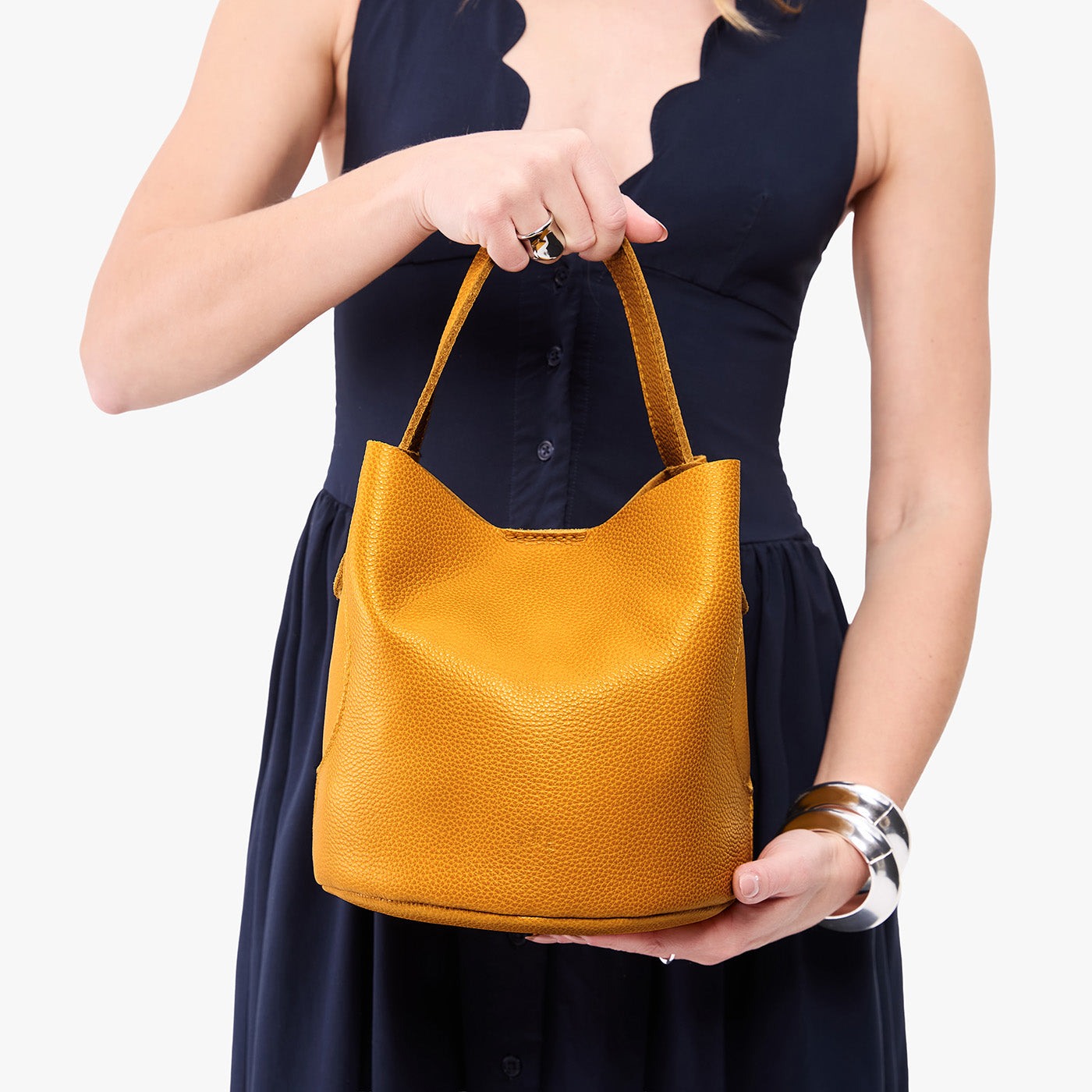 Sunshine*Large | Model holding symmetrical bucket bag with handle, latch closure, and removable crossbody strap