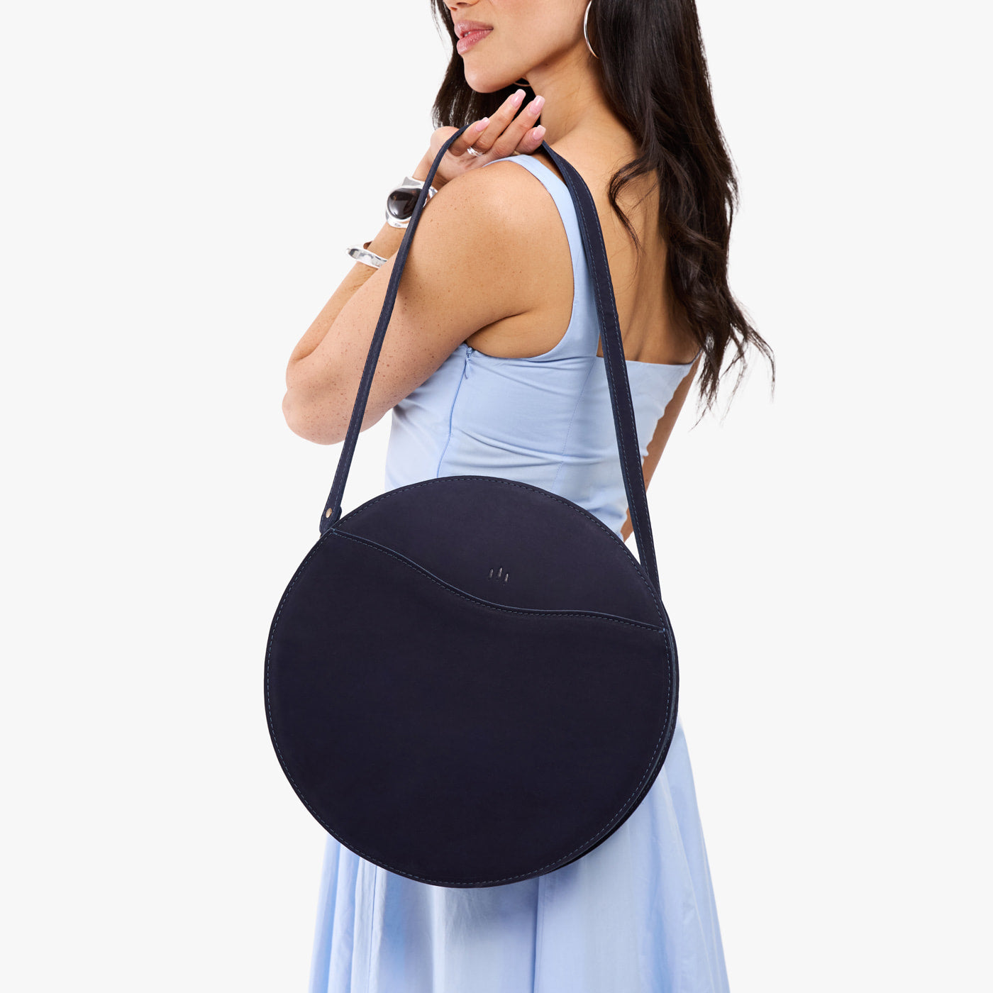 Velvet Blue | Model carrying large circle shaped leather bag with top zipper and carrying strap