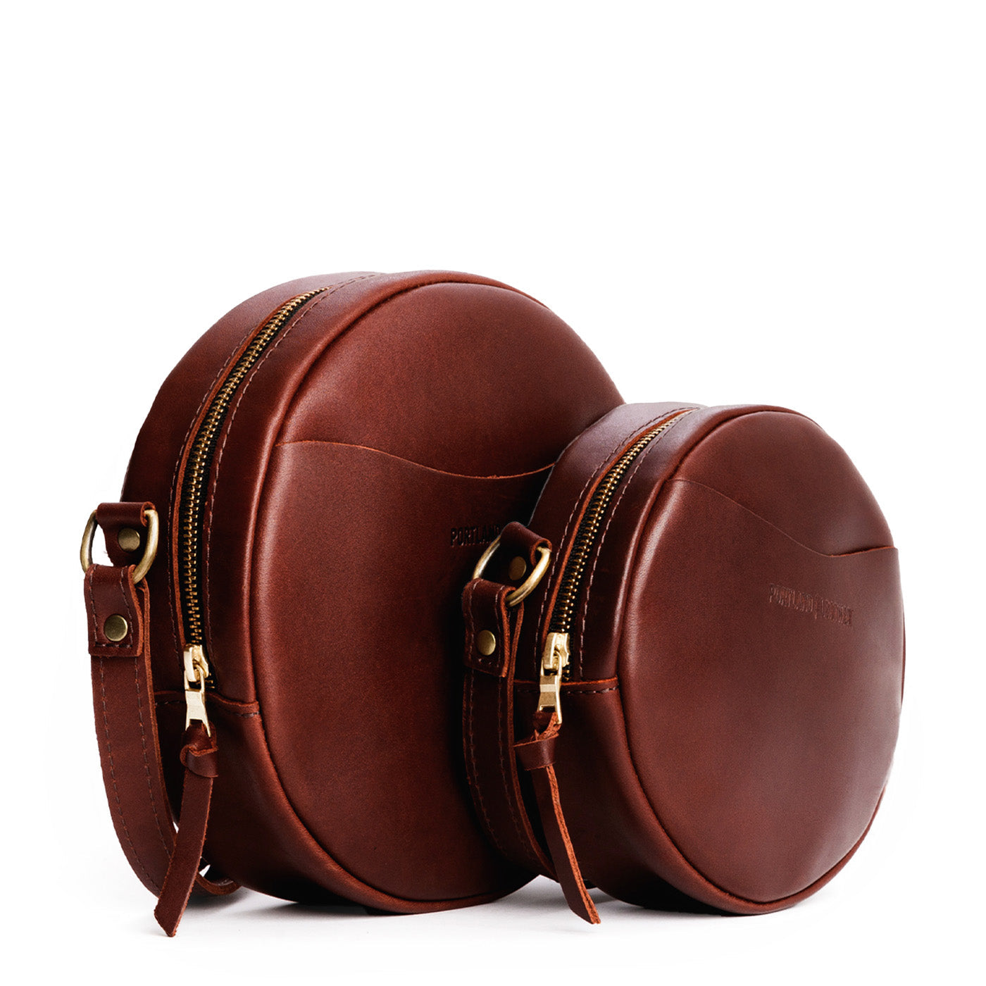 Cognac | Size comparison image of small and large circle shaped crossbody bags with top zipper