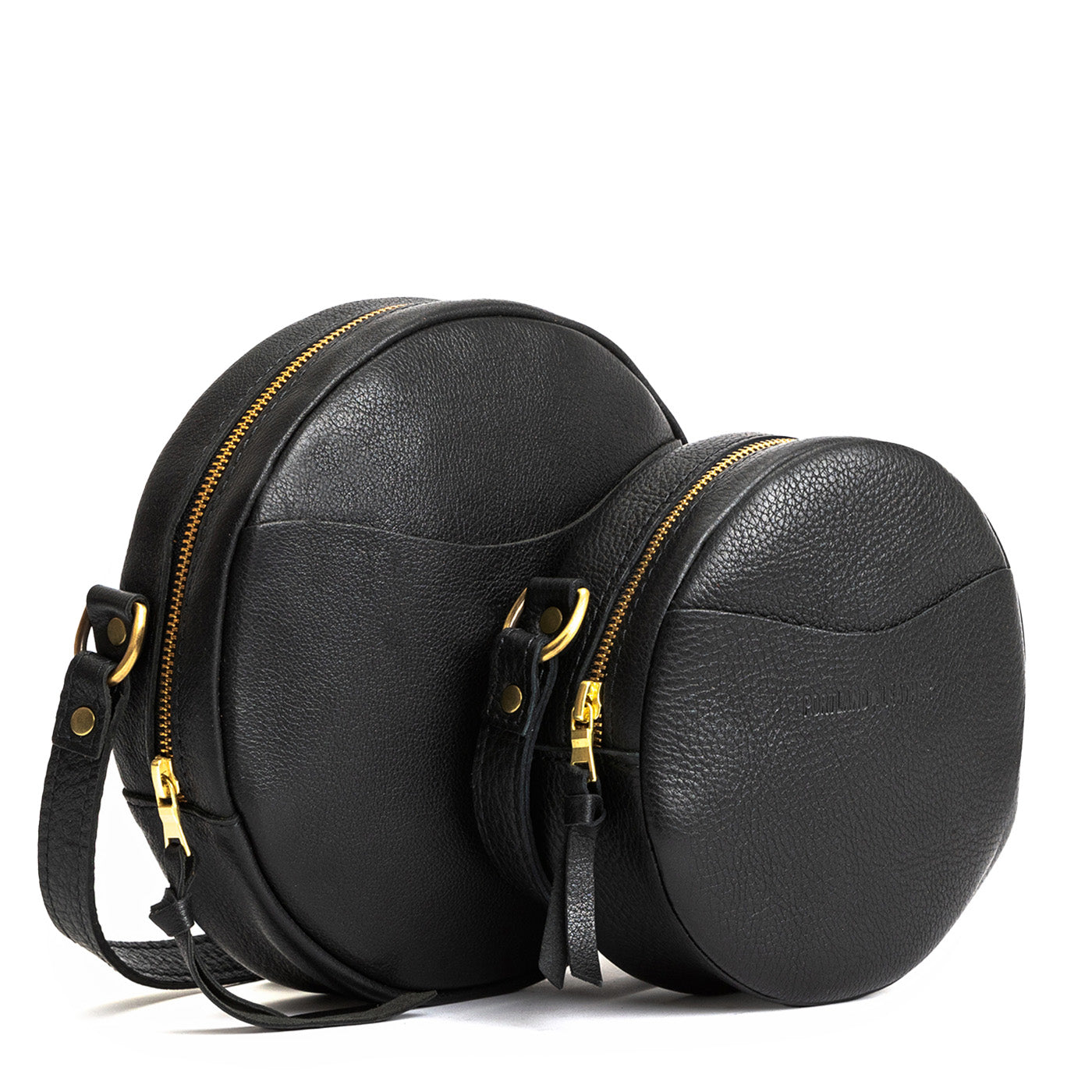 Pebbled--black | Size comparison image of small and large circle shaped crossbody bags with top zipper