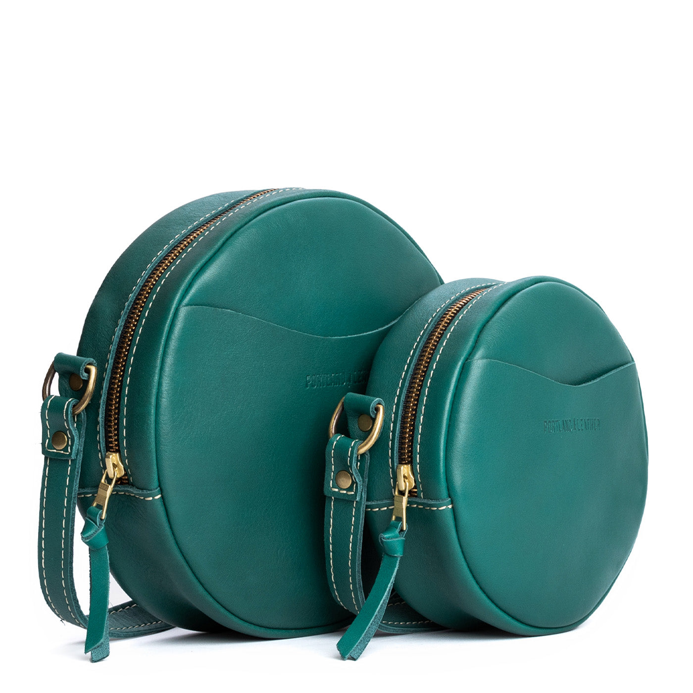 Peacock | Size comparison image of small and large circle shaped crossbody bags with top zipper
