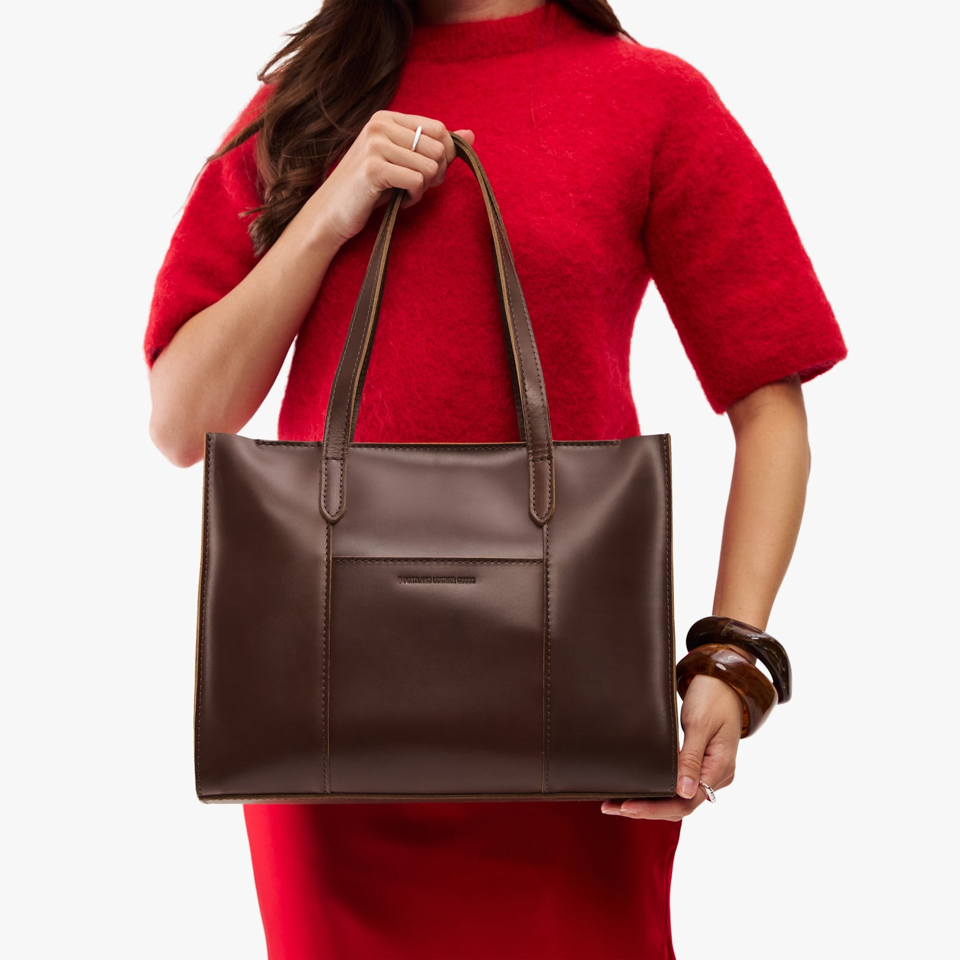 Chocolate Brown*East/West | Model wearing structured wide tote bag with overlapping panels and crossbody strap