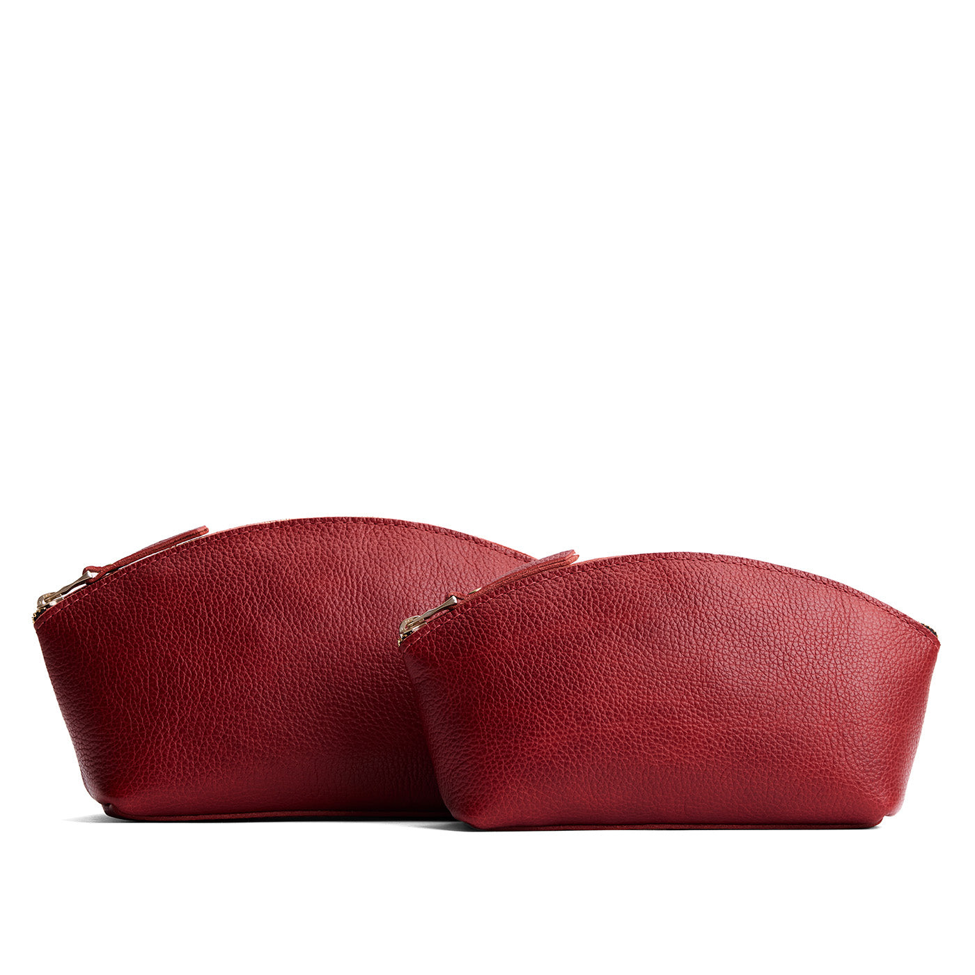 Chili Red | Size comparison shot of two spacious leather makeup bags with curved seams and top zipper