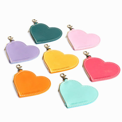 All Variants | Seven heart-shaped leather pouch keychains with zipper top and lobster clasp