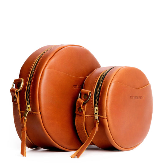 Honey | Size comparison image of small and large circle shaped crossbody bags with top zipper
