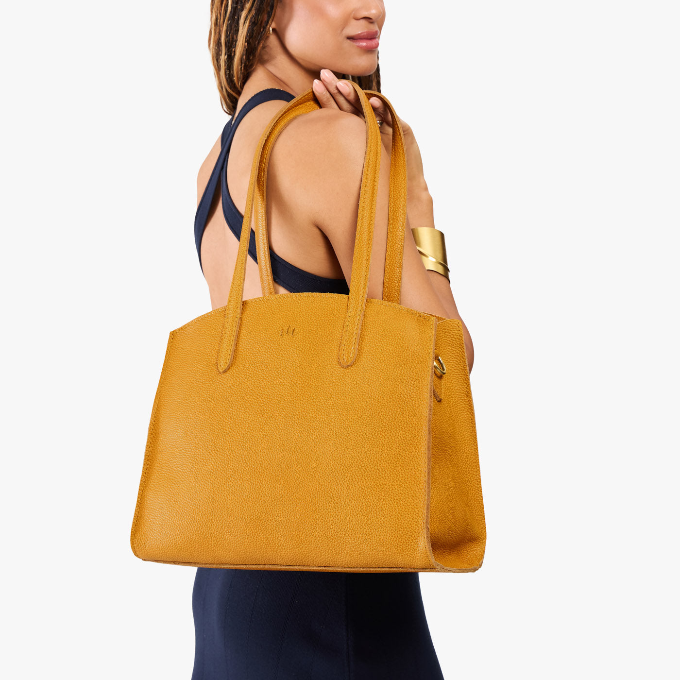 Sunshine*Large | Model carrying leather tote bag with handles, adjustable crossbody strap, and two back pockets