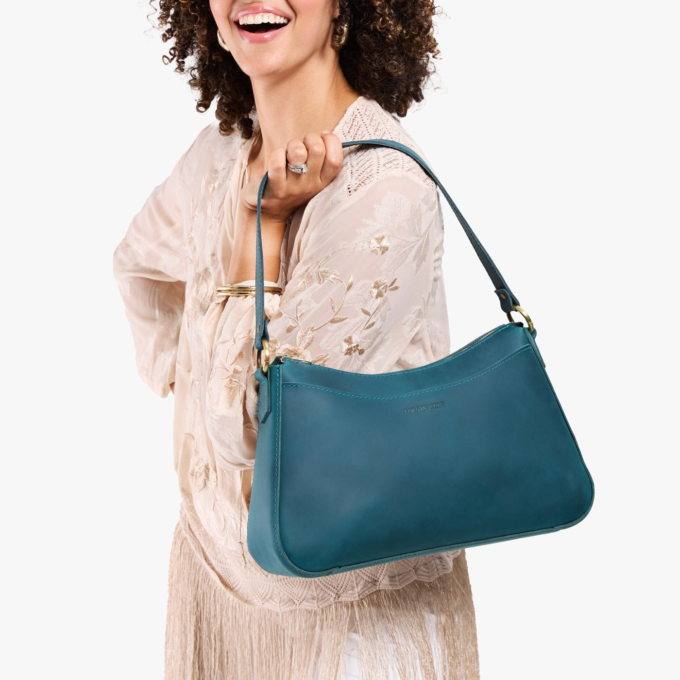 Westward Blue*Large | Model holding a bean shaped shoulder bag with a zipper closure