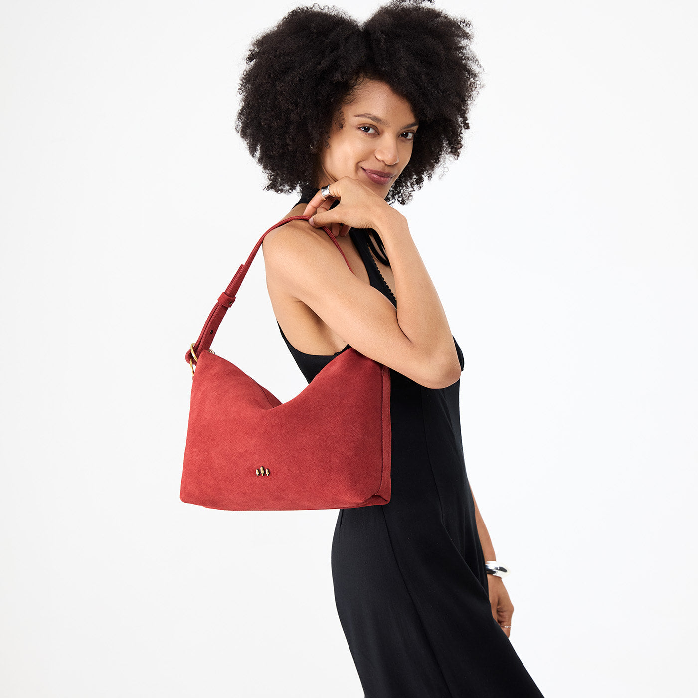 Cinnabar*Large | Model holding a Slouchy Shoulder Bag that has a zipper opening and three metal tree emblems