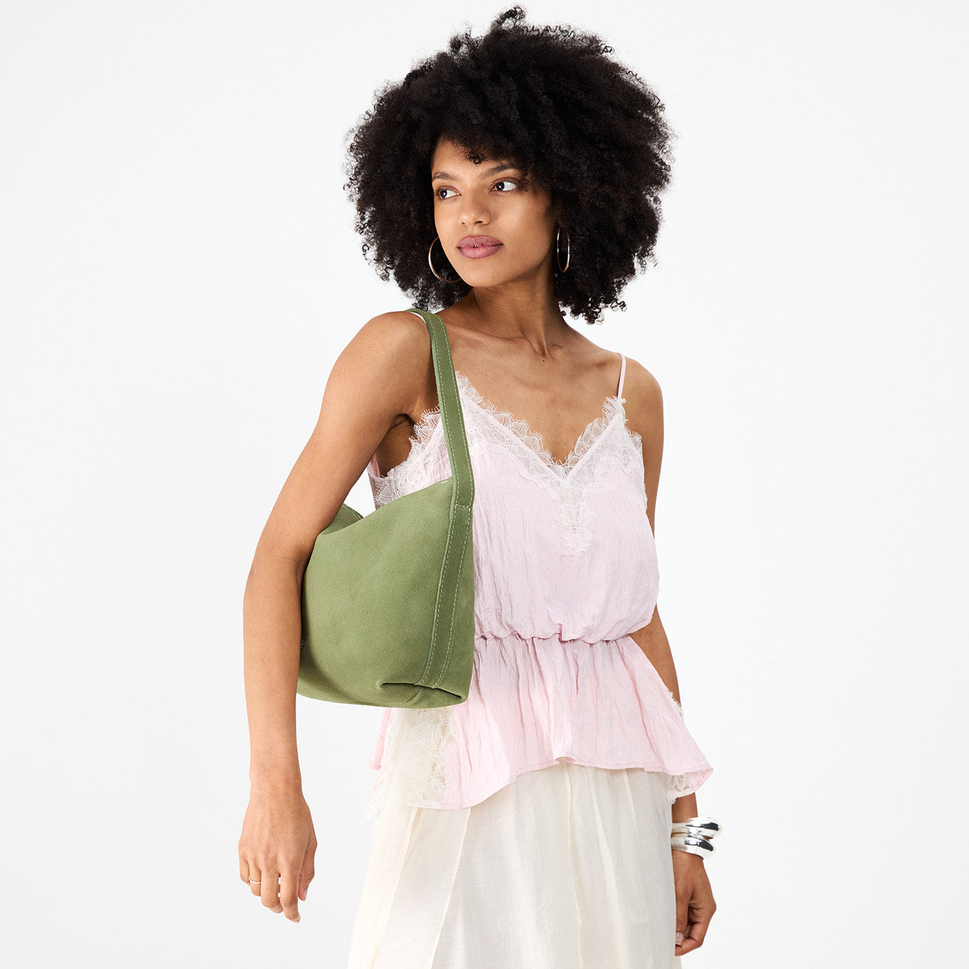 Laurel*Large | Model holding a Slouchy Shoulder Bag that has a zipper opening and three metal tree emblems