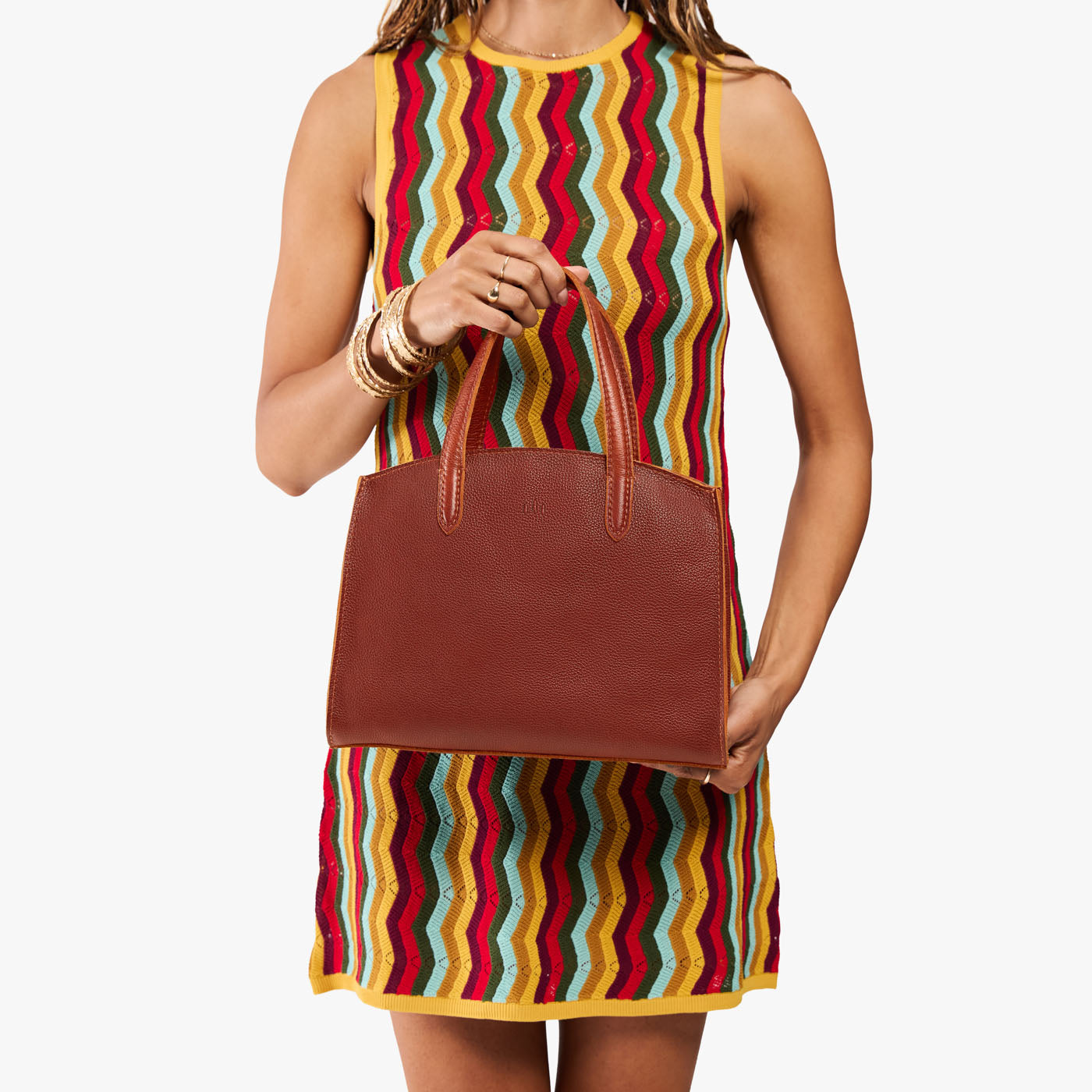 Nutmeg*Medium | Model carrying leather tote bag with handles, adjustable crossbody strap, and two back pockets