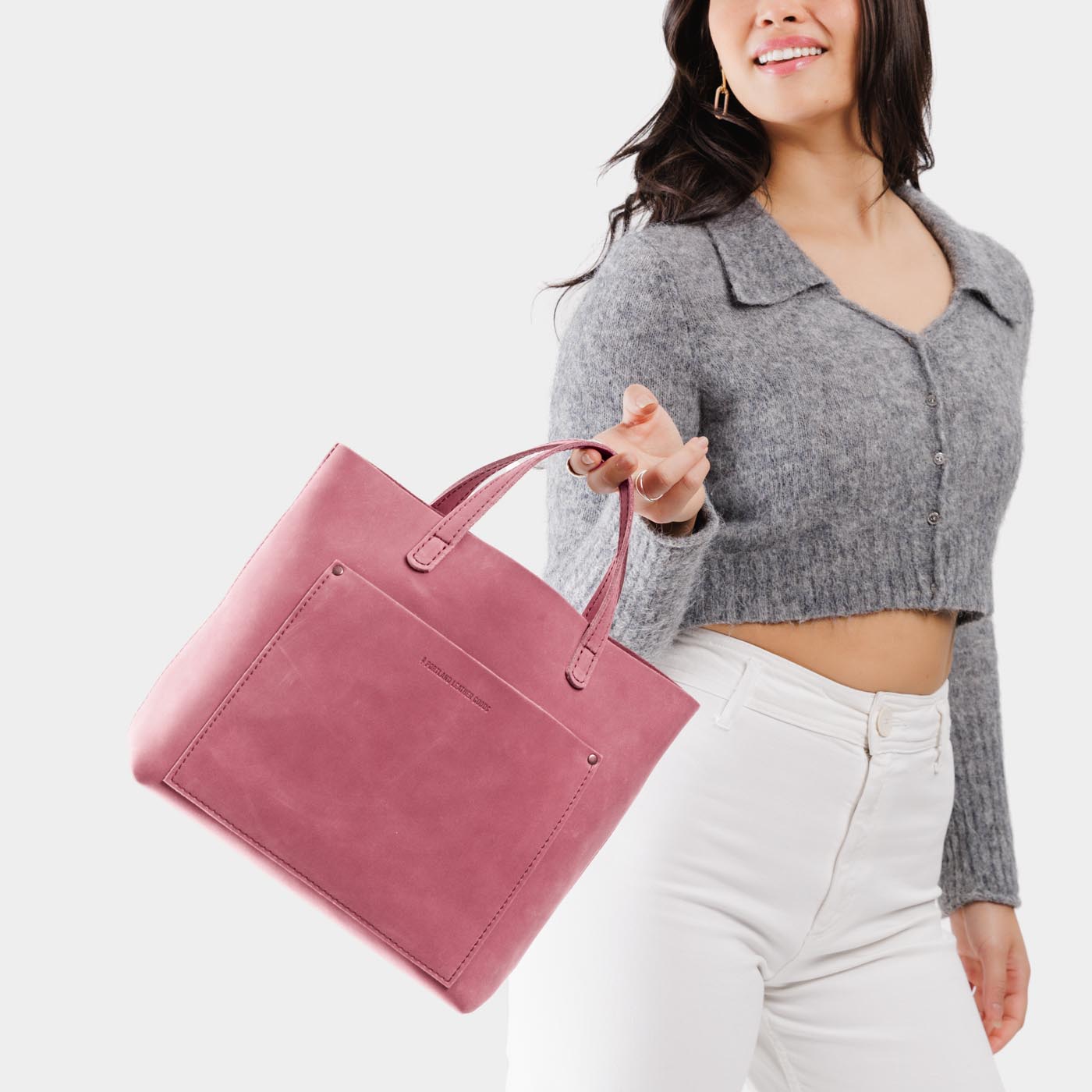 Foxglove | Model holding midsize crossbody tote with handles and a pocket