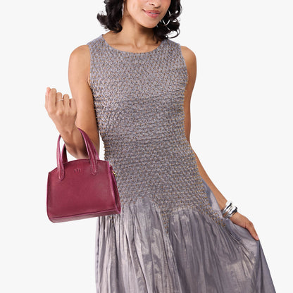 Orchid*Mini | Model carrying small leather tote bag with handles, adjustable crossbody strap, and one back pocket