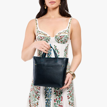 Boreal*Zipper | Model holding crossbody tote bag with zipper closure and front pocket