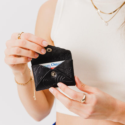 Dahlia | Model holding small leather wallet with scalloped edge open