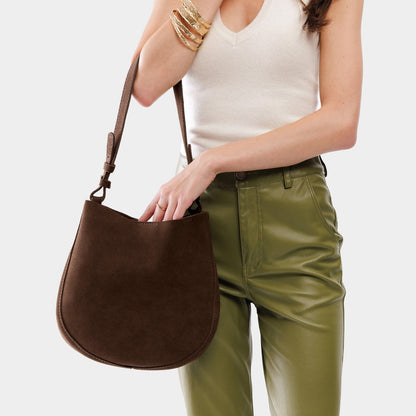 Stagecoach*Medium | Woman wearing rounded shoulder bag with adjustable strap on a white background