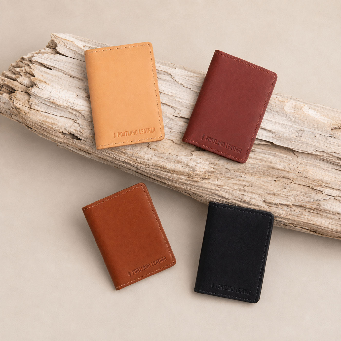 Nero | Group of wallets staged on a piece of drift wood