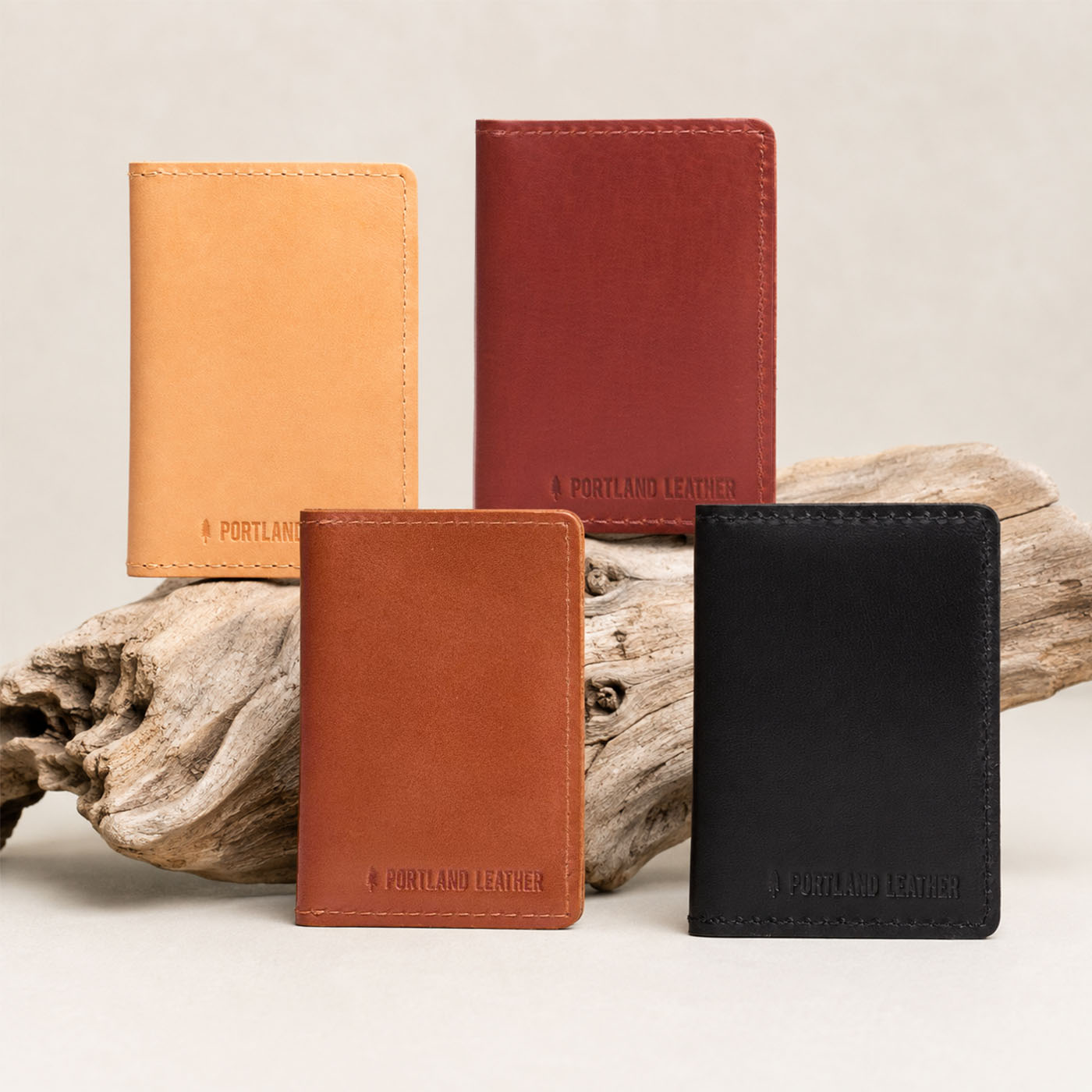 Toscano | Group of wallets staged on a piece of drift wood