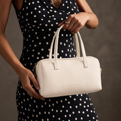 Pebbled Bone*Large | Model holding mini duffle shaped handbag with crossbody strap