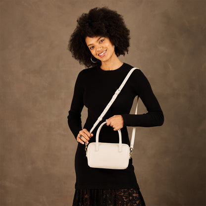 Pebbled Bone*Small | Model holding mini duffle shaped handbag with crossbody strap
