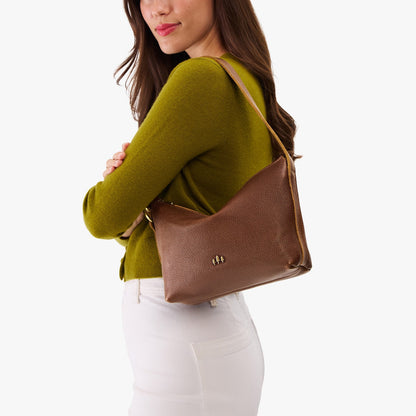 Asheville*Small | Model wearing a petite slouchy leather shoulder bag with zipper opening and three metal tree emblems