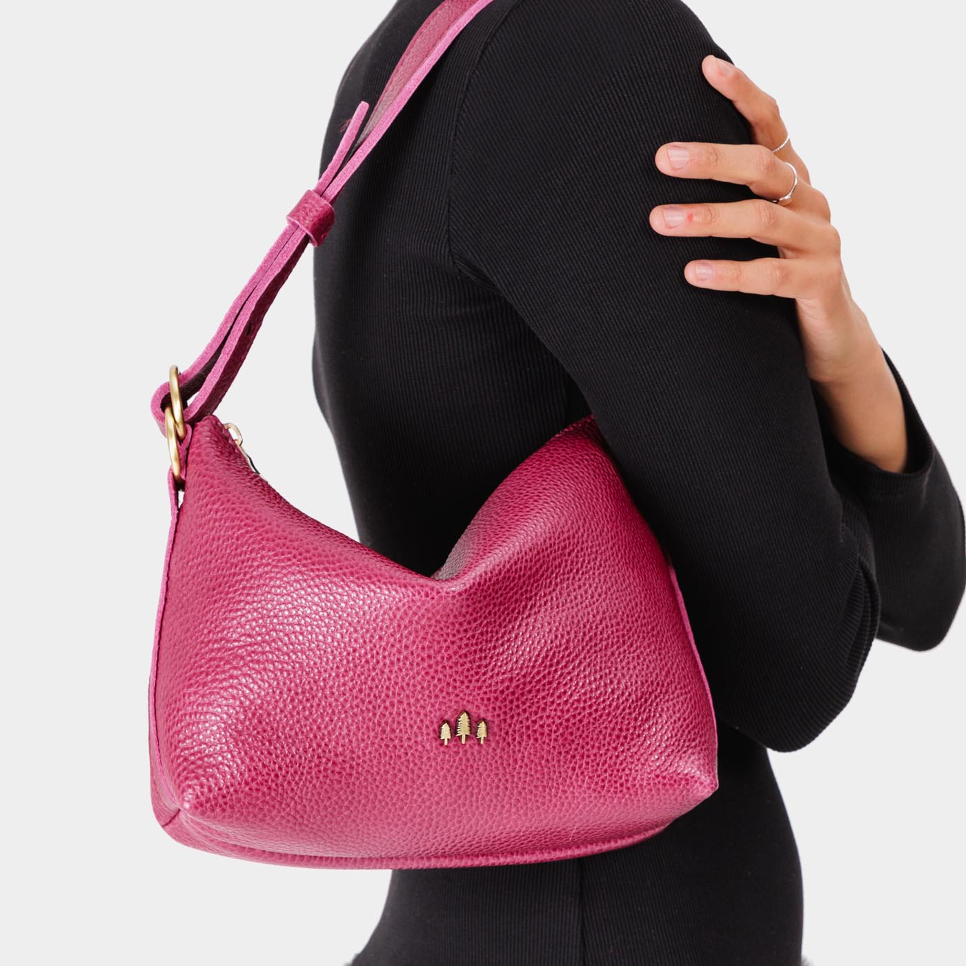 Cosmo*Small | Model wearing petite slouchy leather shoulder bag with zipper opening and three metal tree emblems