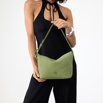 Laurel*Small | Model holding a Slouchy Shoulder Bag that has a zipper opening and three metal tree emblems