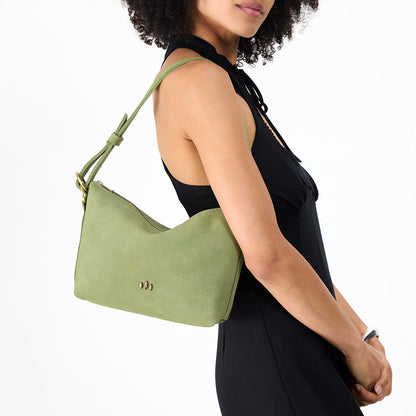 Laurel*Small | Model holding a Slouchy Shoulder Bag that has a zipper opening and three metal tree emblems