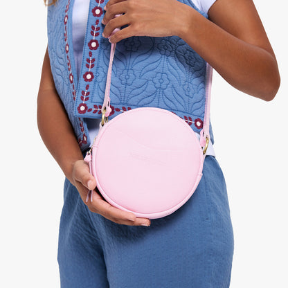 Pinkaboo | Model wearing a circle shaped crossbody bag with top zipper and gold accents