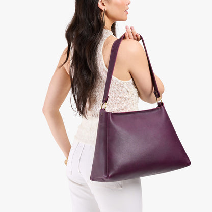 Plum*Large | Model carrying large triangular shoulder bag with antiqued brass finished hardware