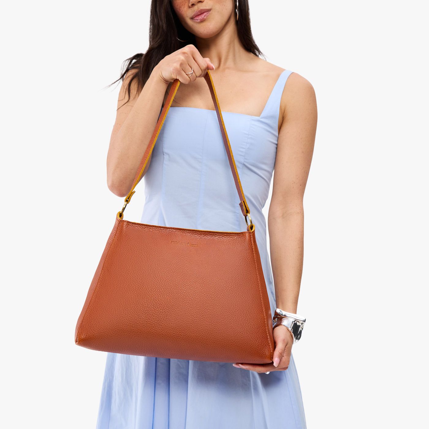 Sienna*Large | Model holding large triangular shoulder bag with antiqued brass finished hardware