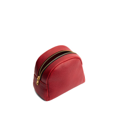 Chili Red | Curved top leather pouch with zipper opening, flat base, and three metal tree emblems in front